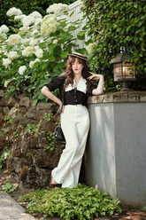 a lady in a patchwork top and a pair of white pants